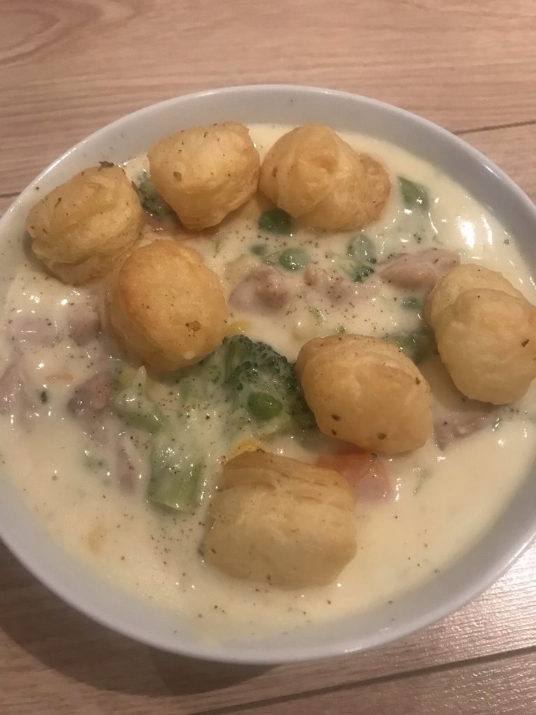 Image of chicken pot pie soup with vegtables, cream and garnished with puff patry