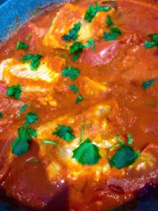 Cod Poached in Spicy Tomato Sauce Garnished with Coriander Leaves.