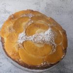 Upside down peach cake decorated iwth icing sugar