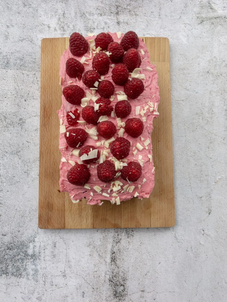 Aerial view of the cake shows casing buttercream, raspberries and white chocolate